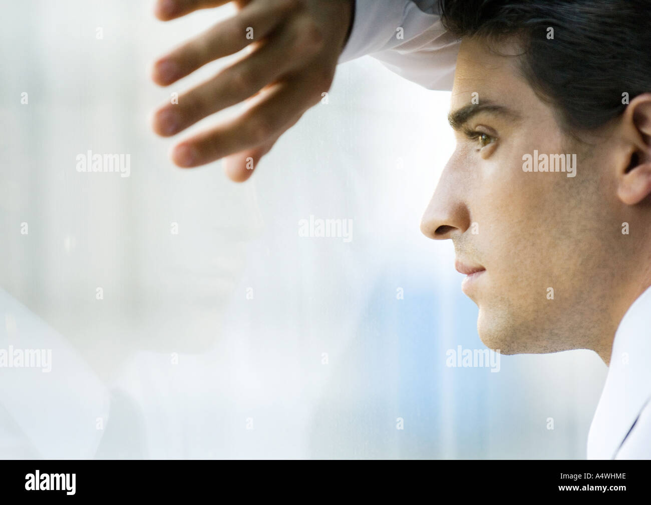 Man looking through window Stock Photo