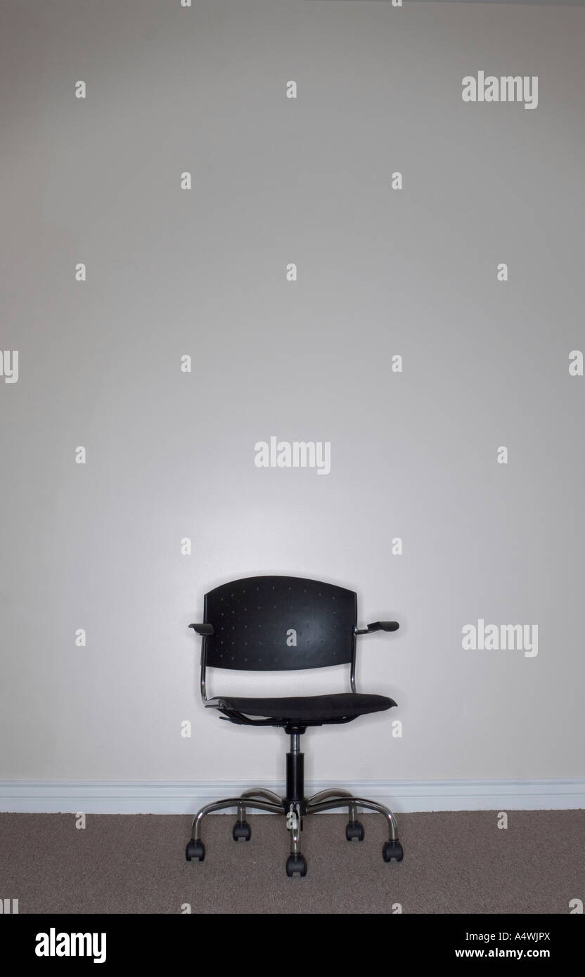 One Business Chair sits alone against a beige wall with nobody sitting