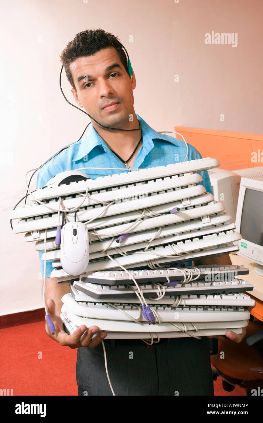 Businessman carrying a large stack of computer keyboards Stock Photo ...