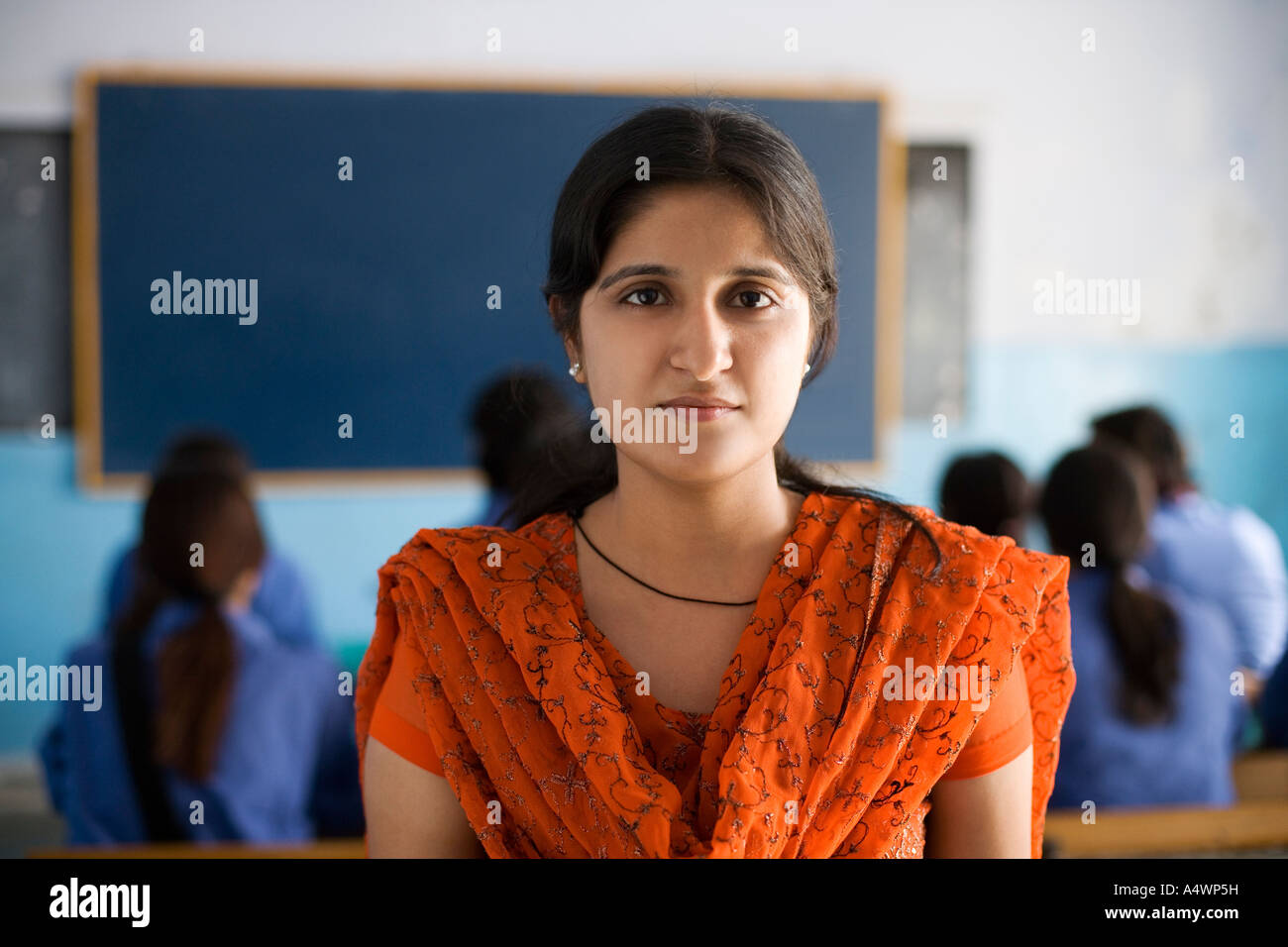 Teacher smiling in classroom Stock Photo - Alamy