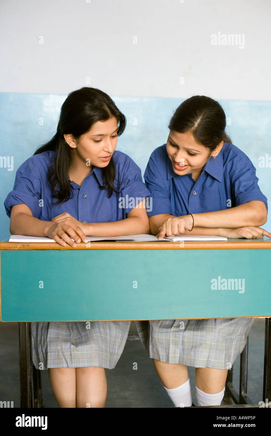 Female students studying at shared desk Stock Photo Alamy