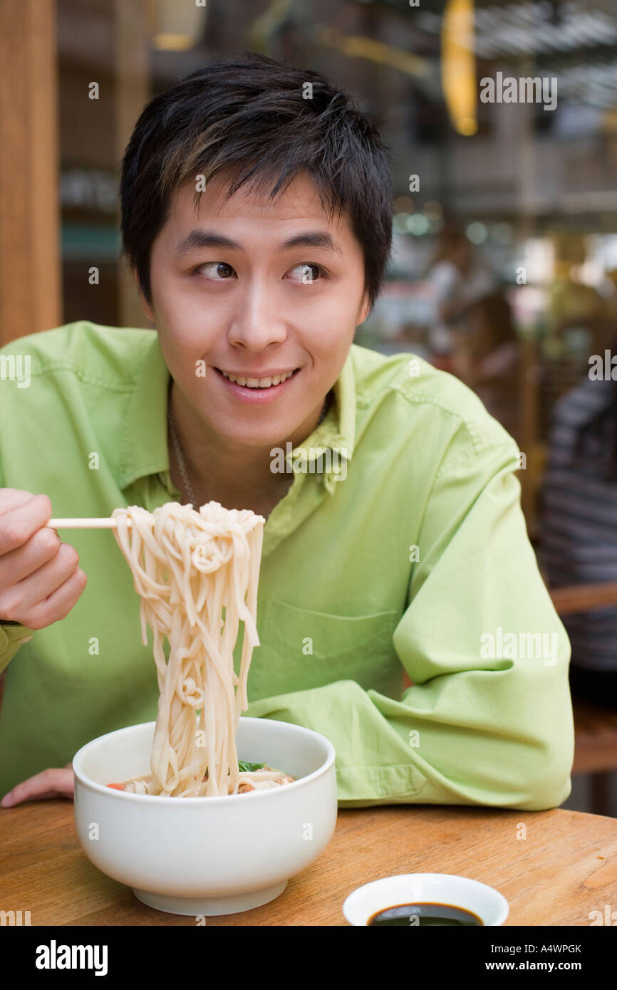 Young Man Eating Noodles Stock Photo - Alamy