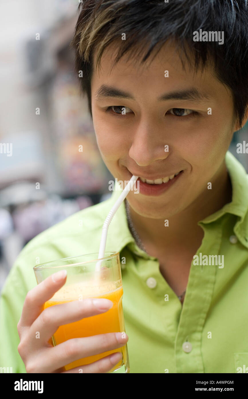 Young man drinking juice Stock Photo Alamy