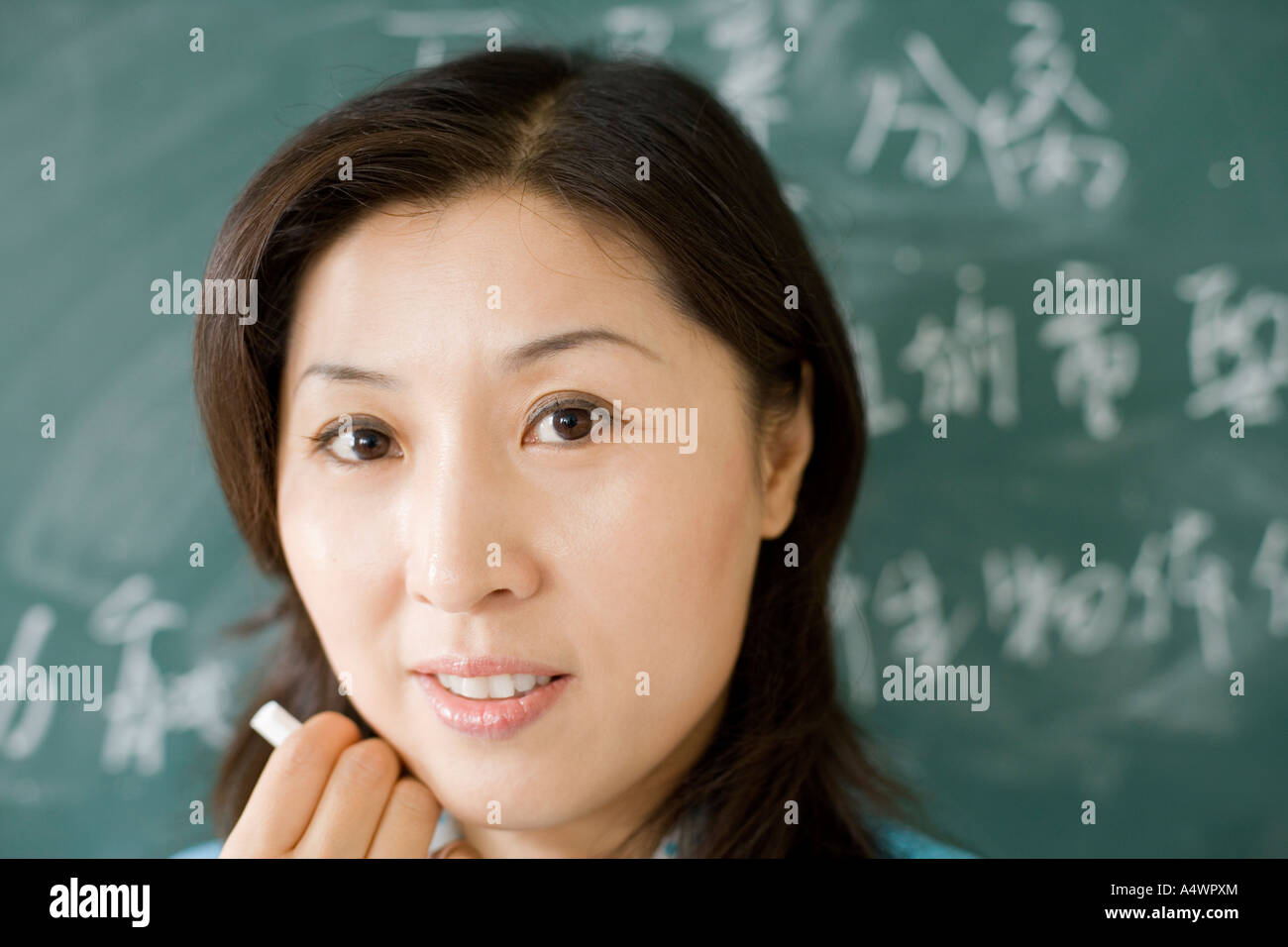 Teacher smiling in front of chalkboard Stock Photo - Alamy