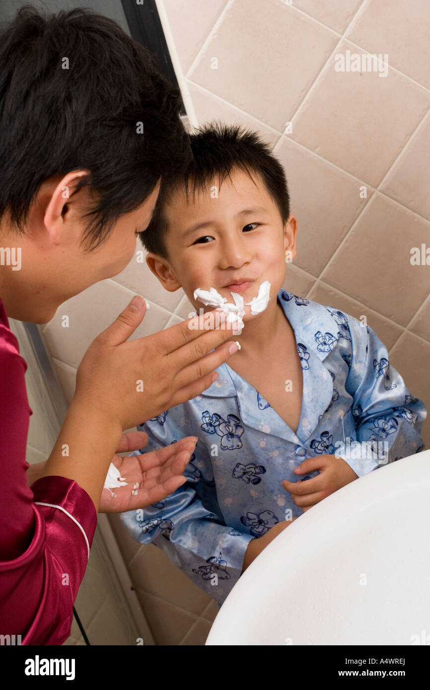 Father spreading shaving cream on son’s face Stock Photo Alamy