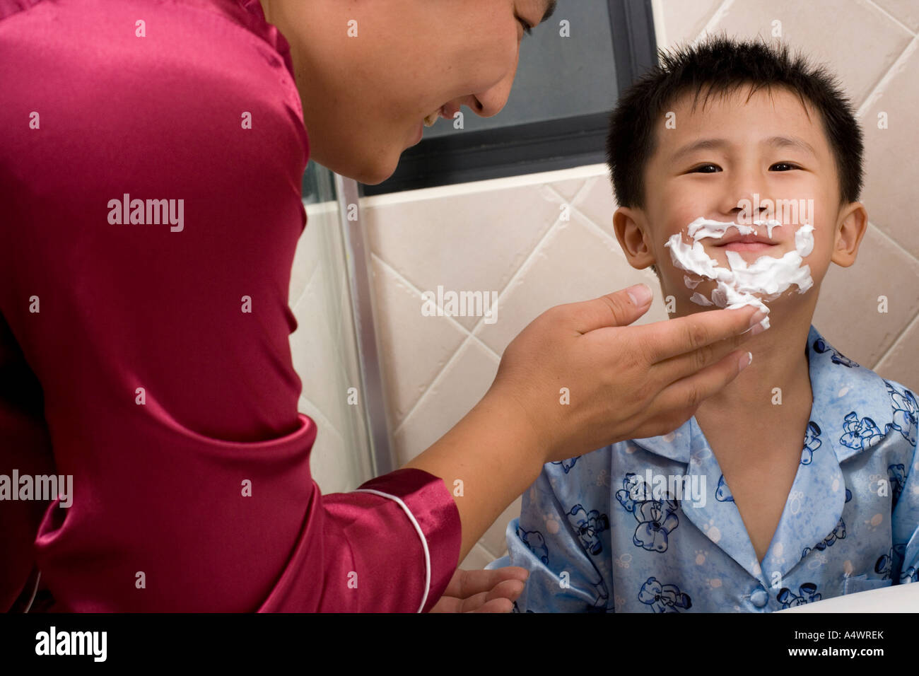 Father spreading shaving cream on son’s face Stock Photo Alamy