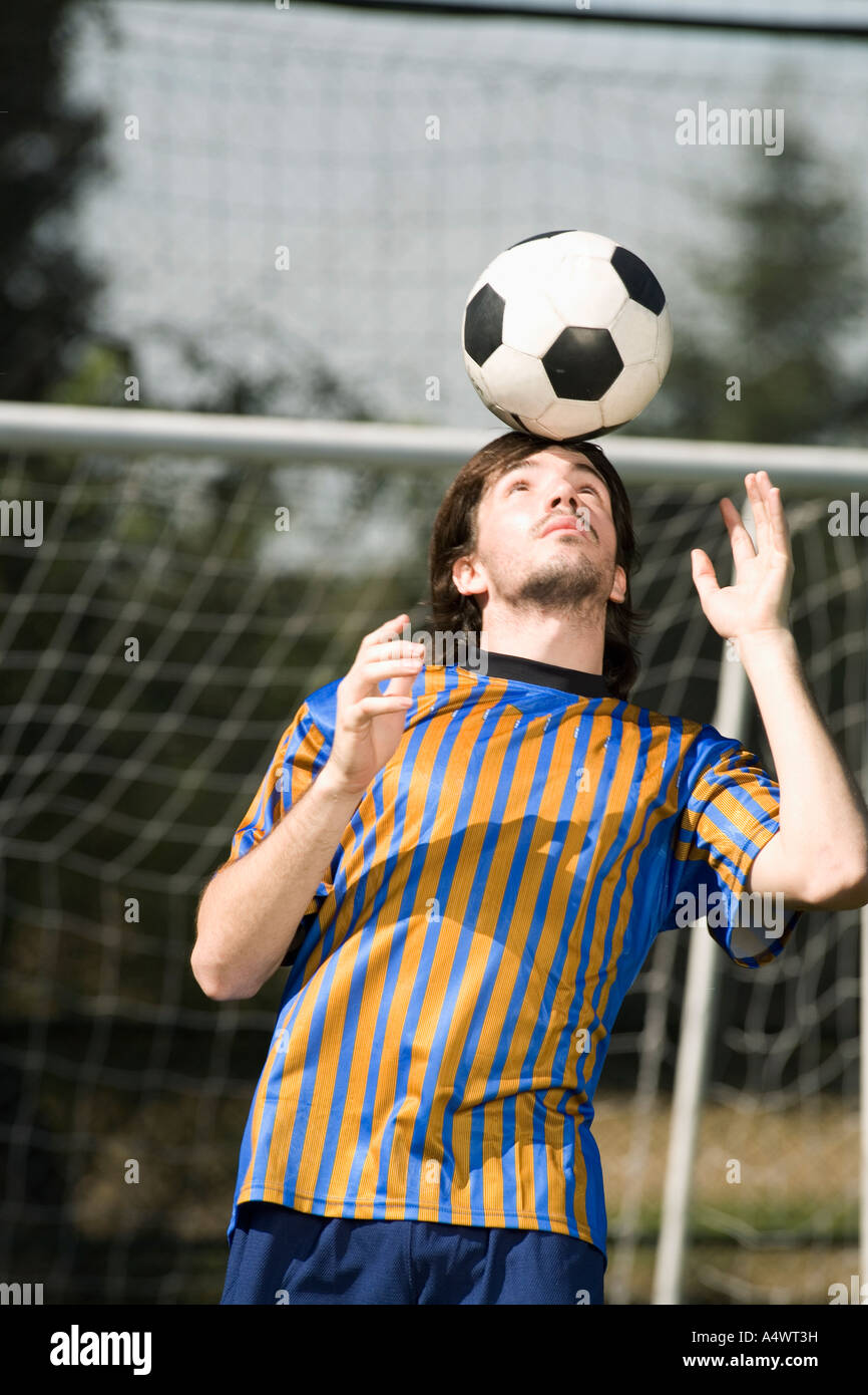 Soccer player balancing the ball on his head Stock Photo Alamy