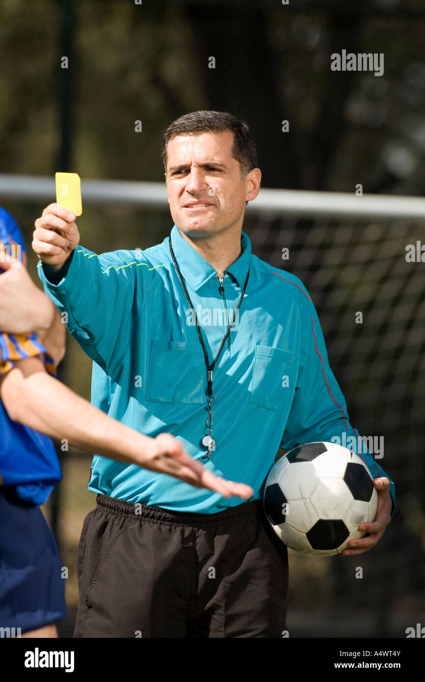 referee showing a soccer player the yellow card Stock Photo