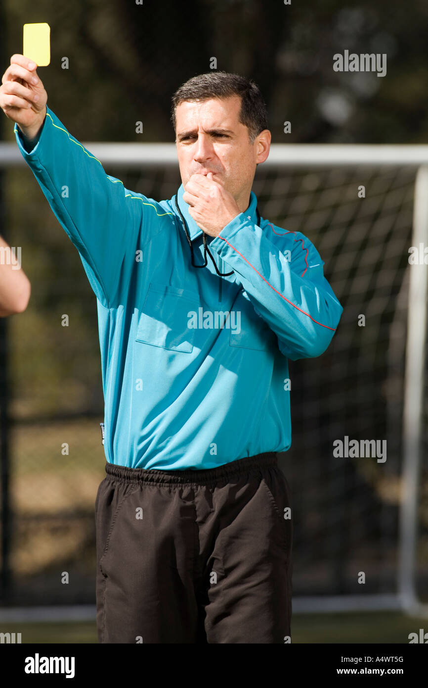referee showing a soccer player the yellow card Stock Photo