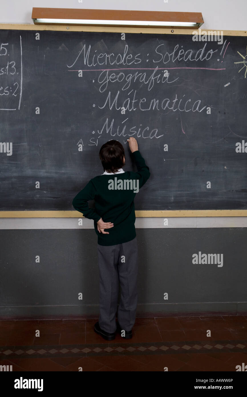 Young student writing on chalkboard in Spanish Stock Photo Alamy