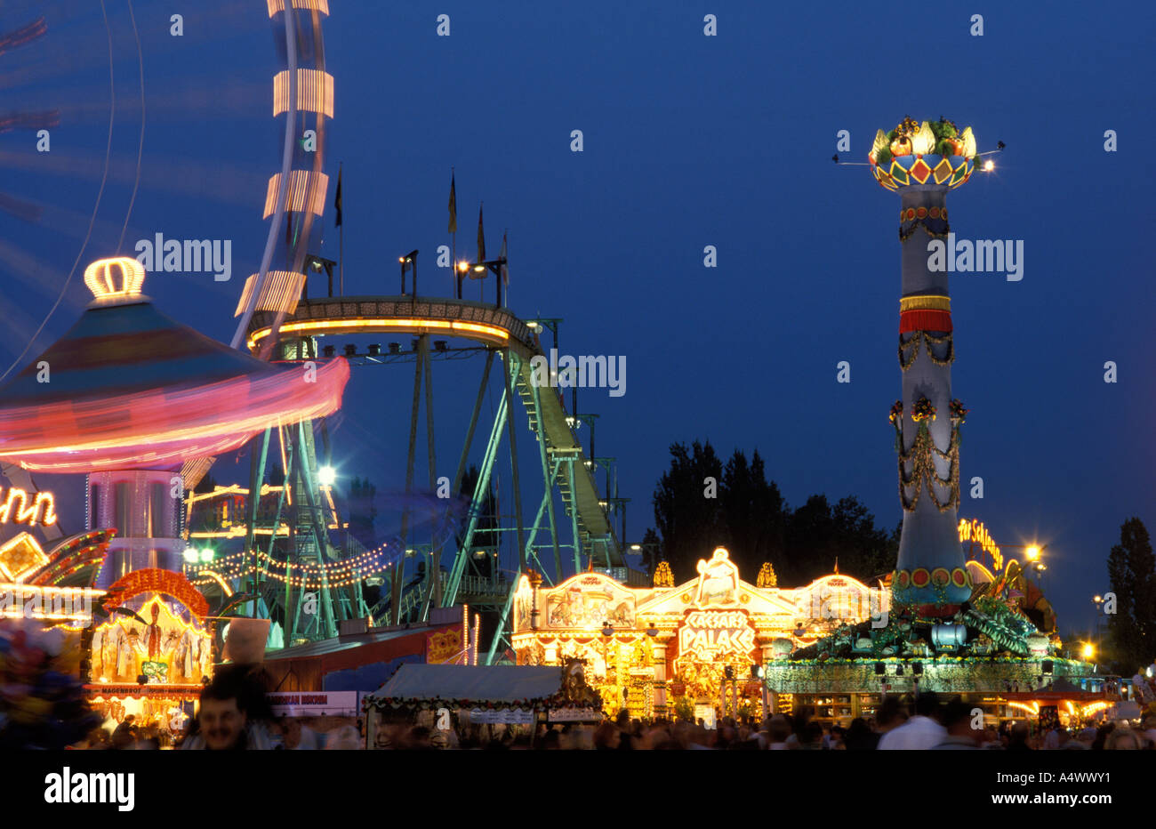 People at the fairground of the festival Cannstatter Volksfest at  night Stuttgart Baden Wuerttemberg Germany Stock Photo