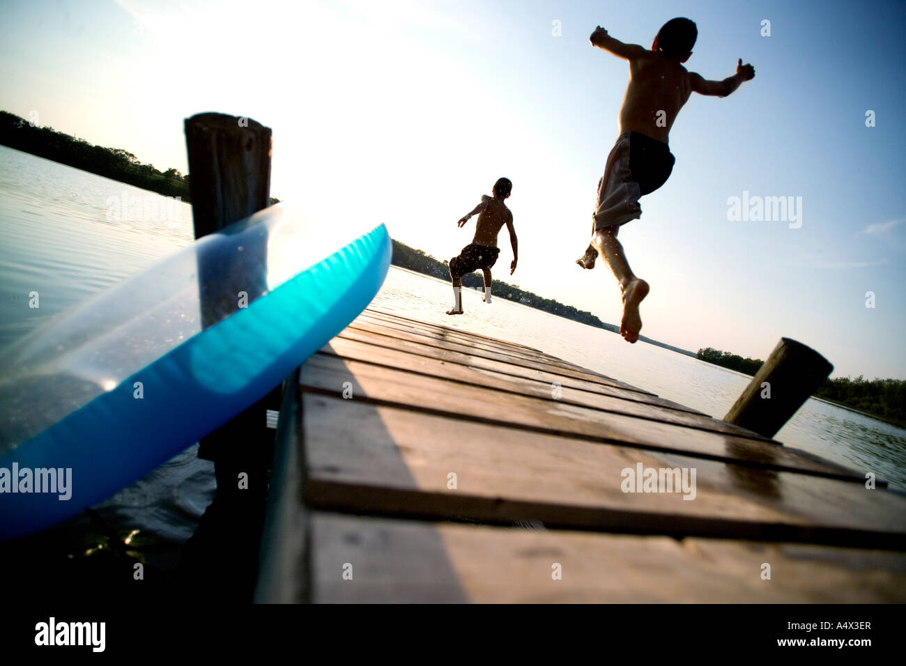 Kids jumping off a dock into a Lake Stock Photo Alamy