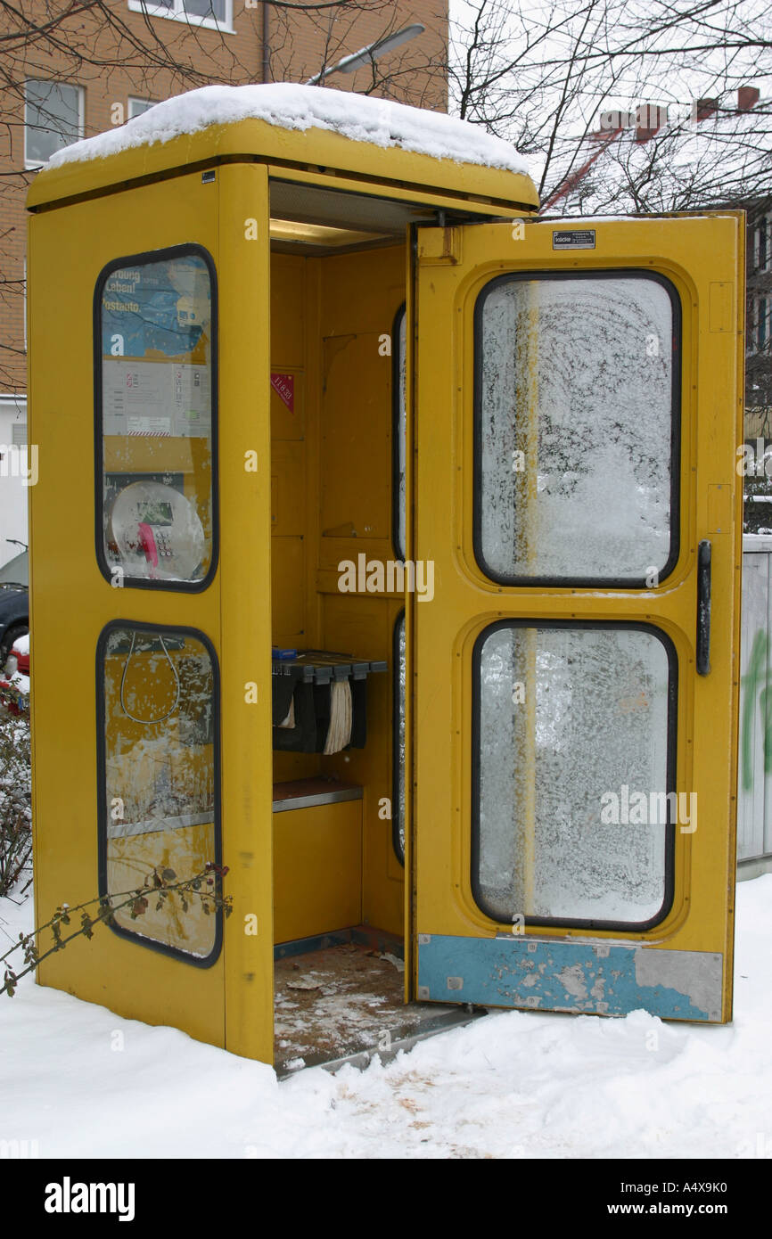 Ice and snow covering a yellow telephone box of the Deutsche Telekom Stock Photo