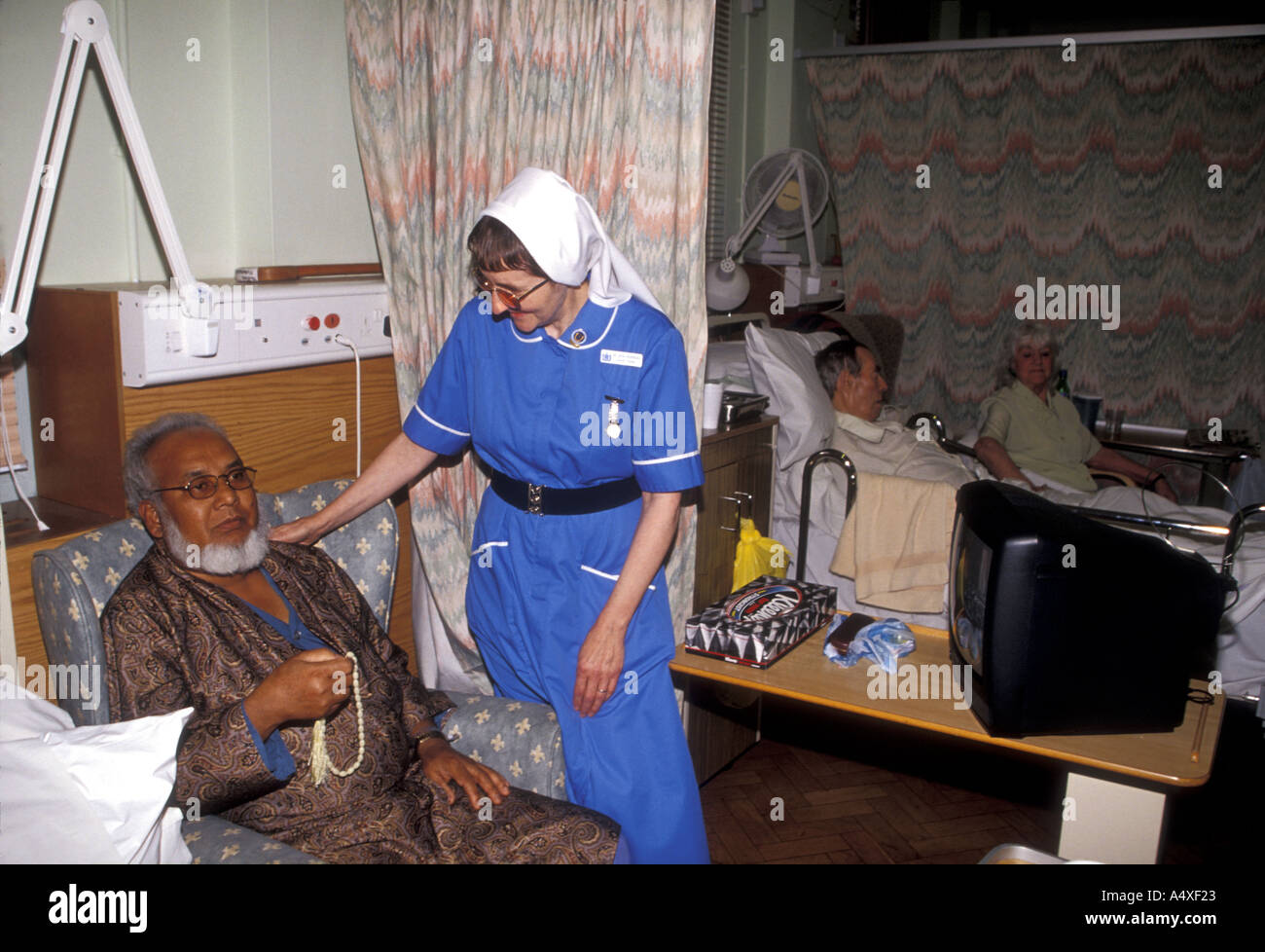 Catholic nursing sister attending Muslim patient St Josephs Hospice, East London Stock Photo