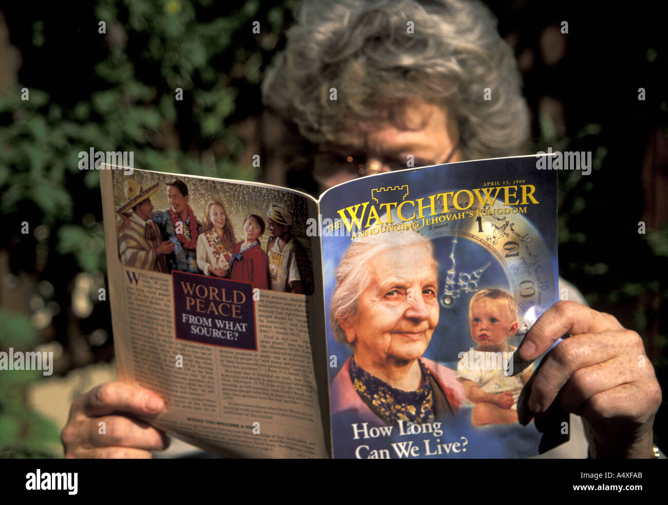 A  woman reading Watchtower magazine of the Jehovah's Witnesses Stock Photo