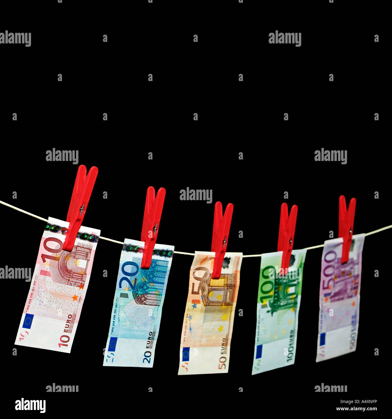 Euro Notes Hanging on a Clothesline Against a Black Background Stock Photo