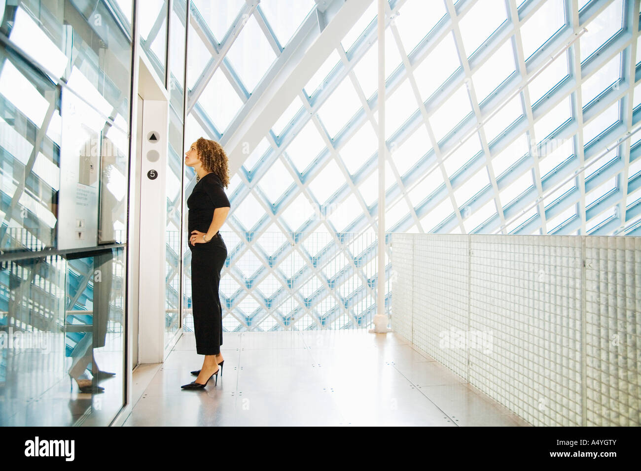 Woman waiting for elevator Stock Photo