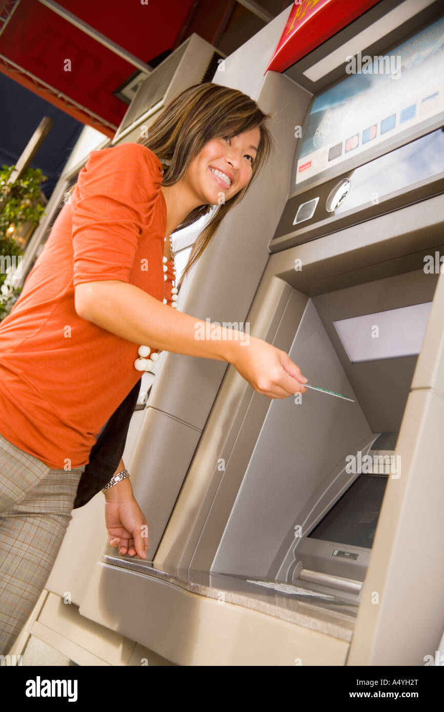 Low angle view of woman using ATM Stock Photo