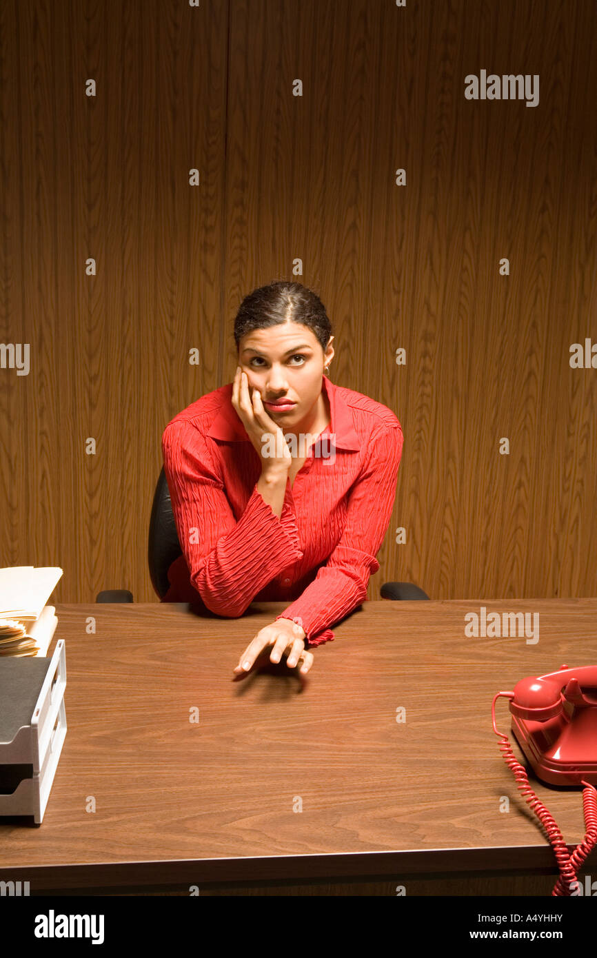 Bored businesswoman at desk Stock Photo