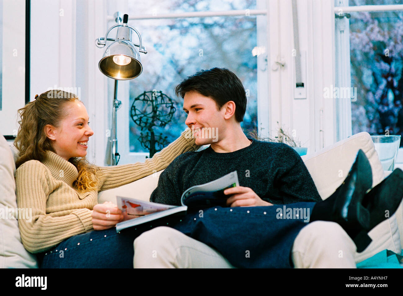Young couple on couch Stock Photo