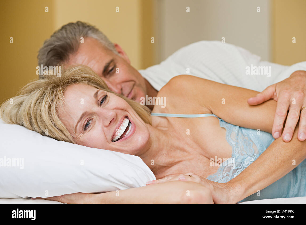 Happy couple lying on bed Stock Photo