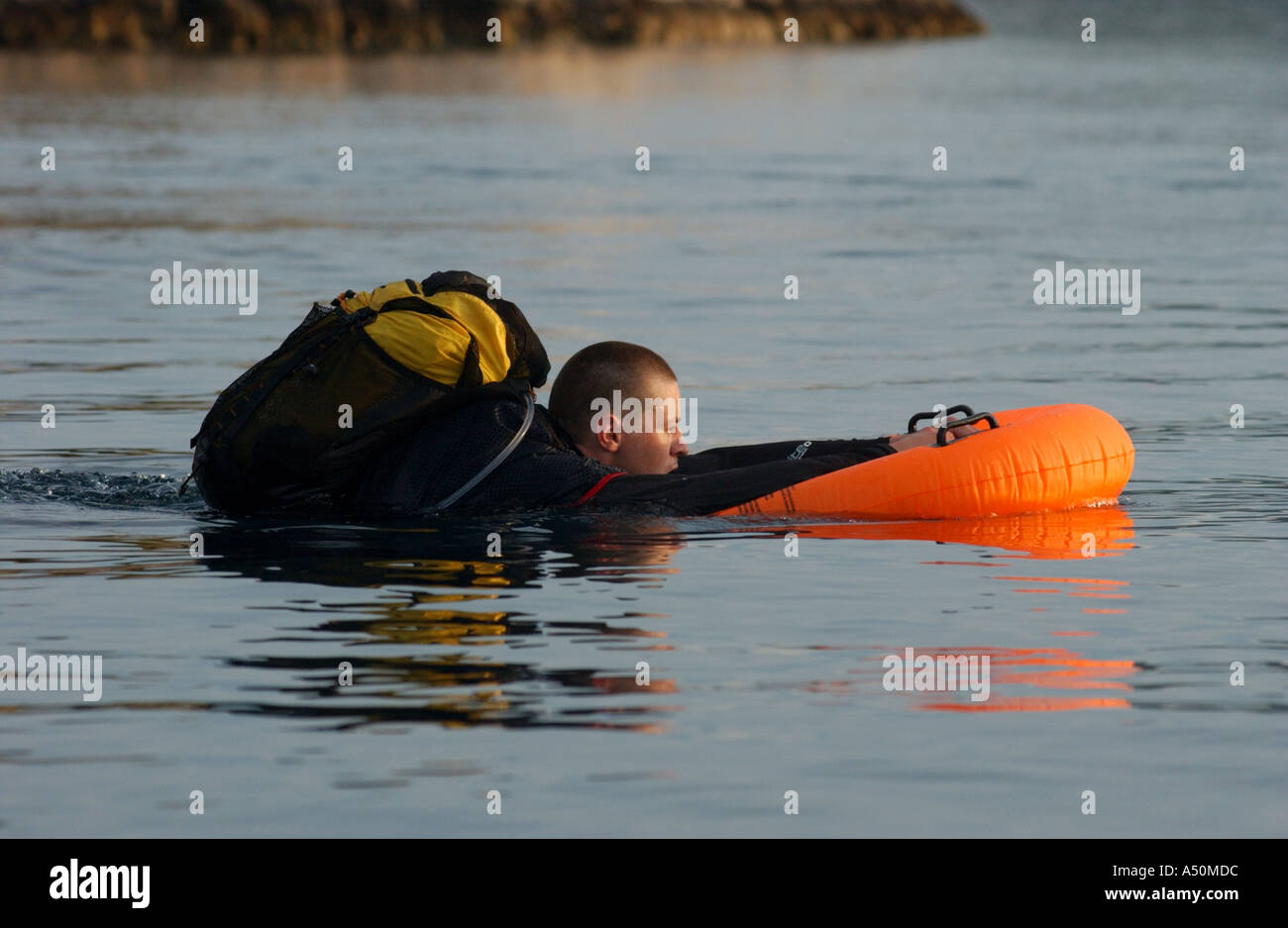 Adventure race athlete swimming with full equipment pack Stock Photo