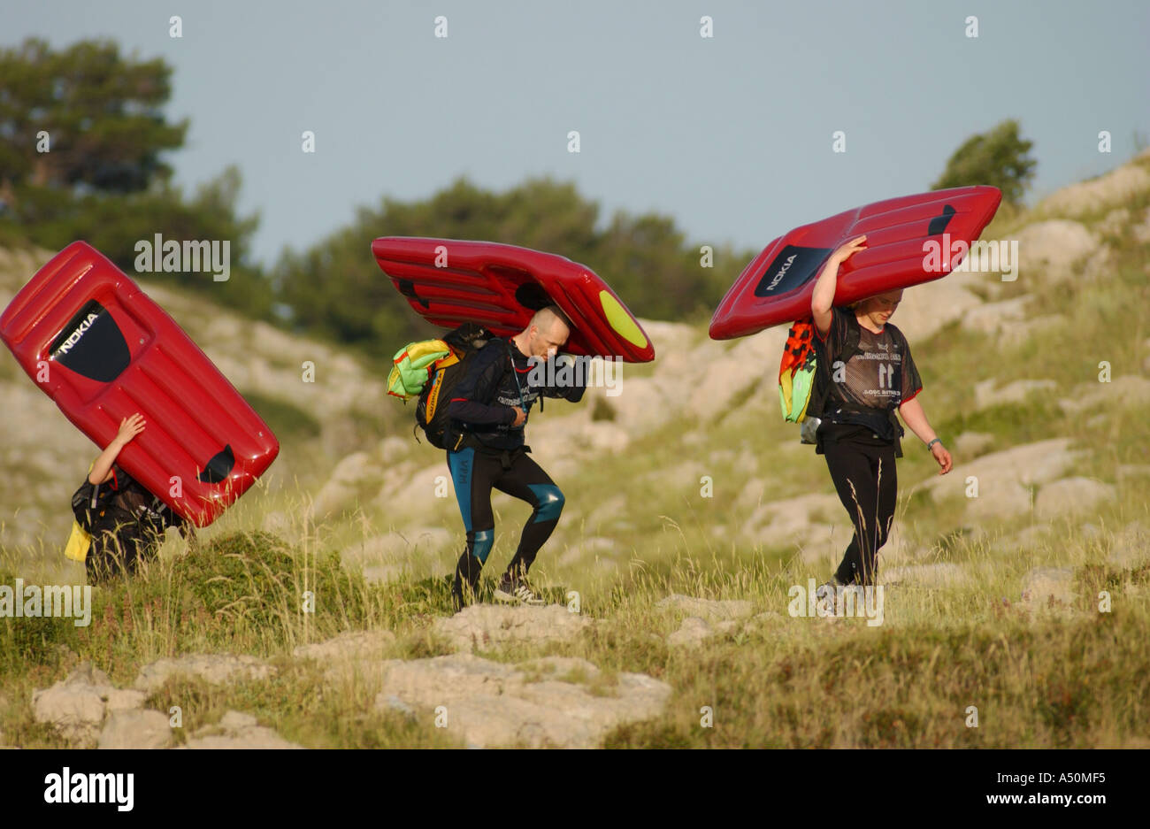 Adventure race athletes with inflatable airbeds for swim shaped like mobile phone Stock Photo