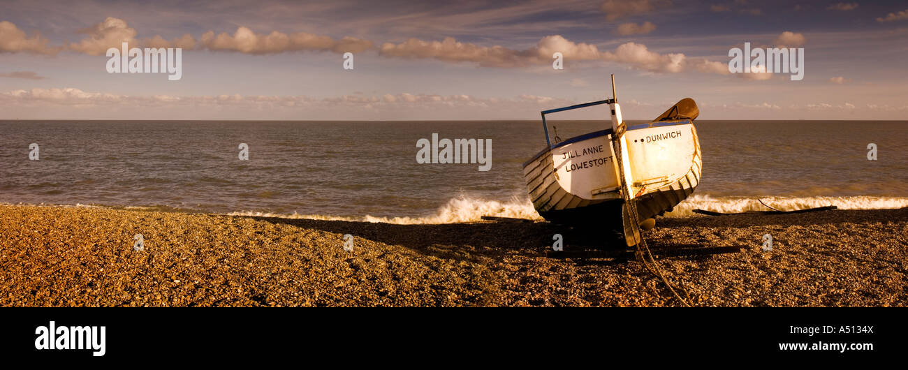 Panoramic image of old wooden fishing boat on shingle beach at Dunwich in Suffolk England UK Stock Photo