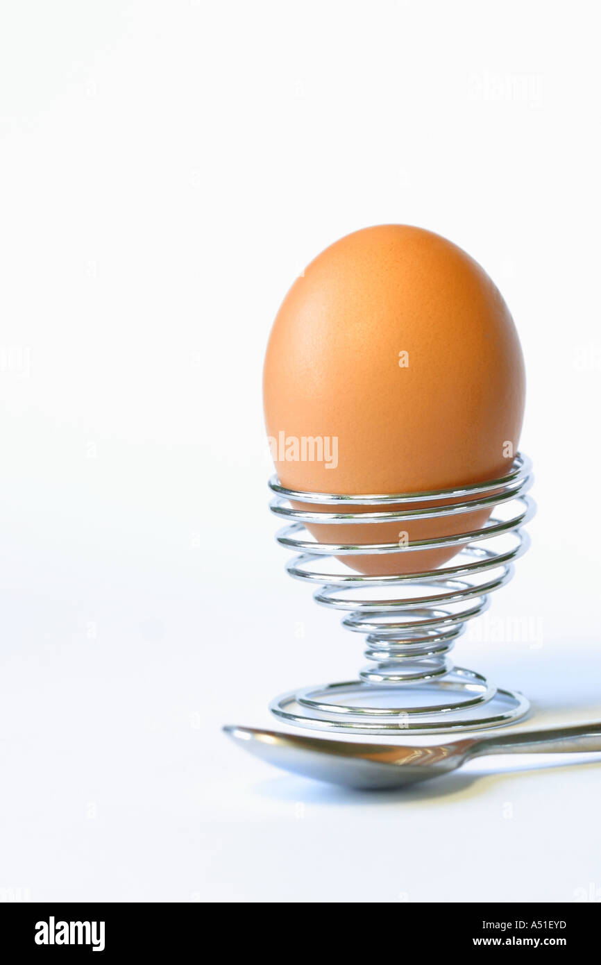 Egg in metal spiral egg cup with spoon Stock Photo