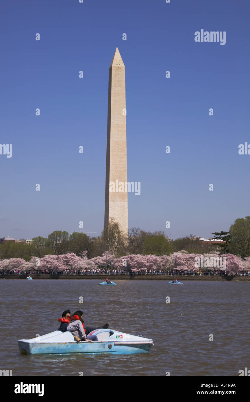 People in paddle boats in the Potomac River Tidal Basin with the Washington Monument behind them