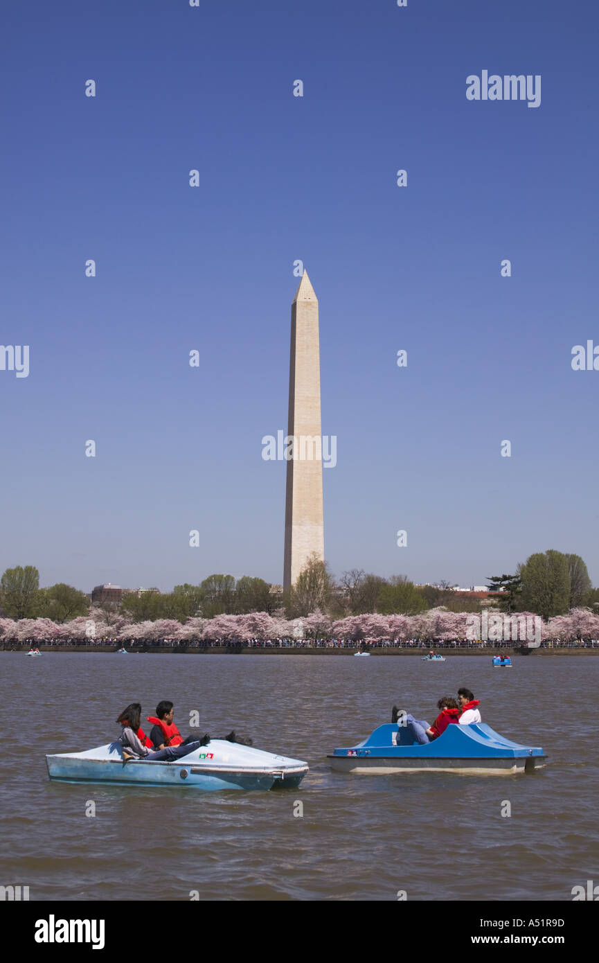 People in paddle boats in the Potomac River Tidal Basin with the Washington Monument behind them