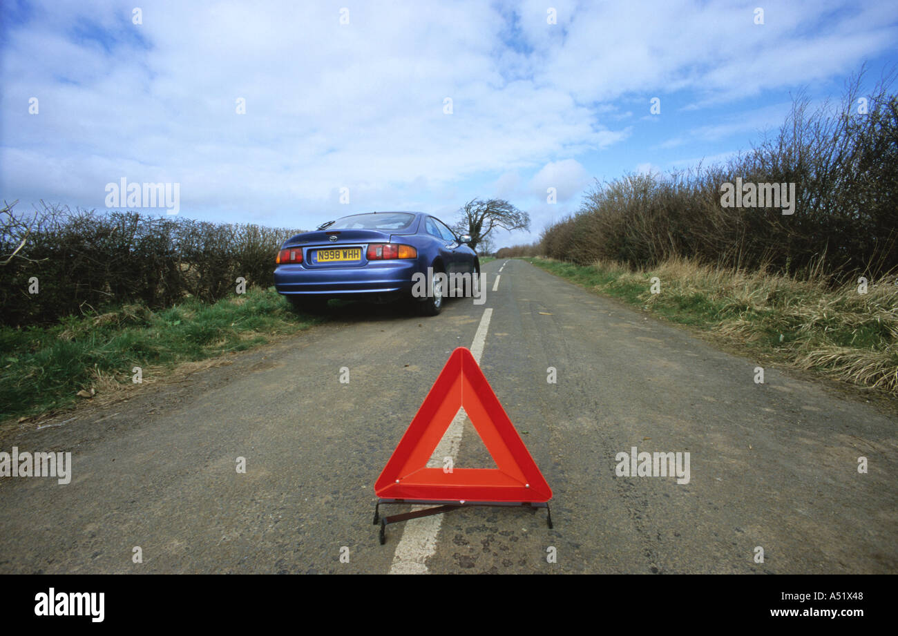 hazard warning triangle by broken down car on country road near leeds yorkshire uk Stock Photo