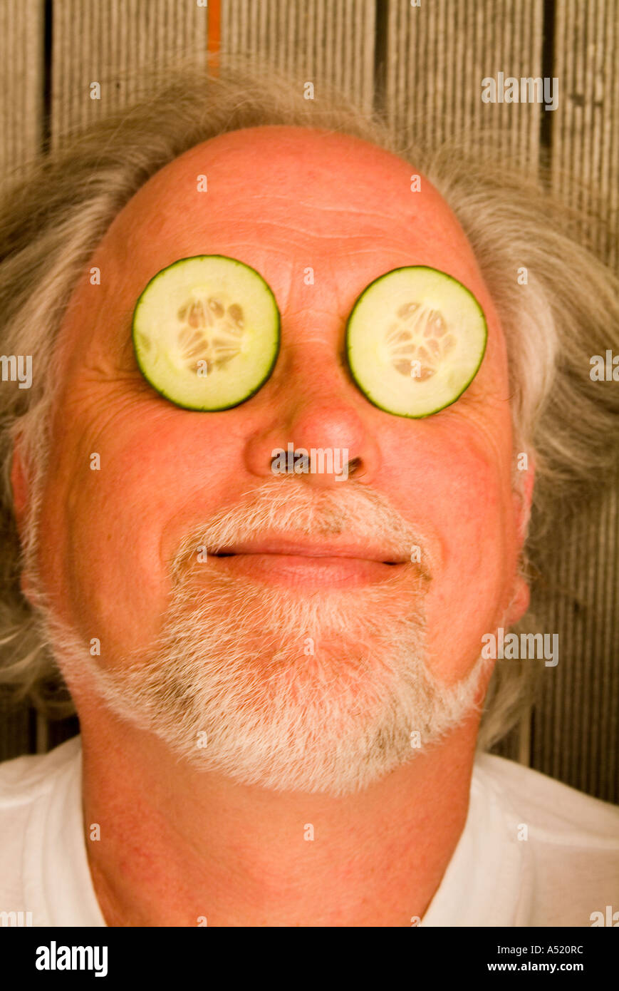 Man with cucumber slices on eyes Stock Photo Alamy