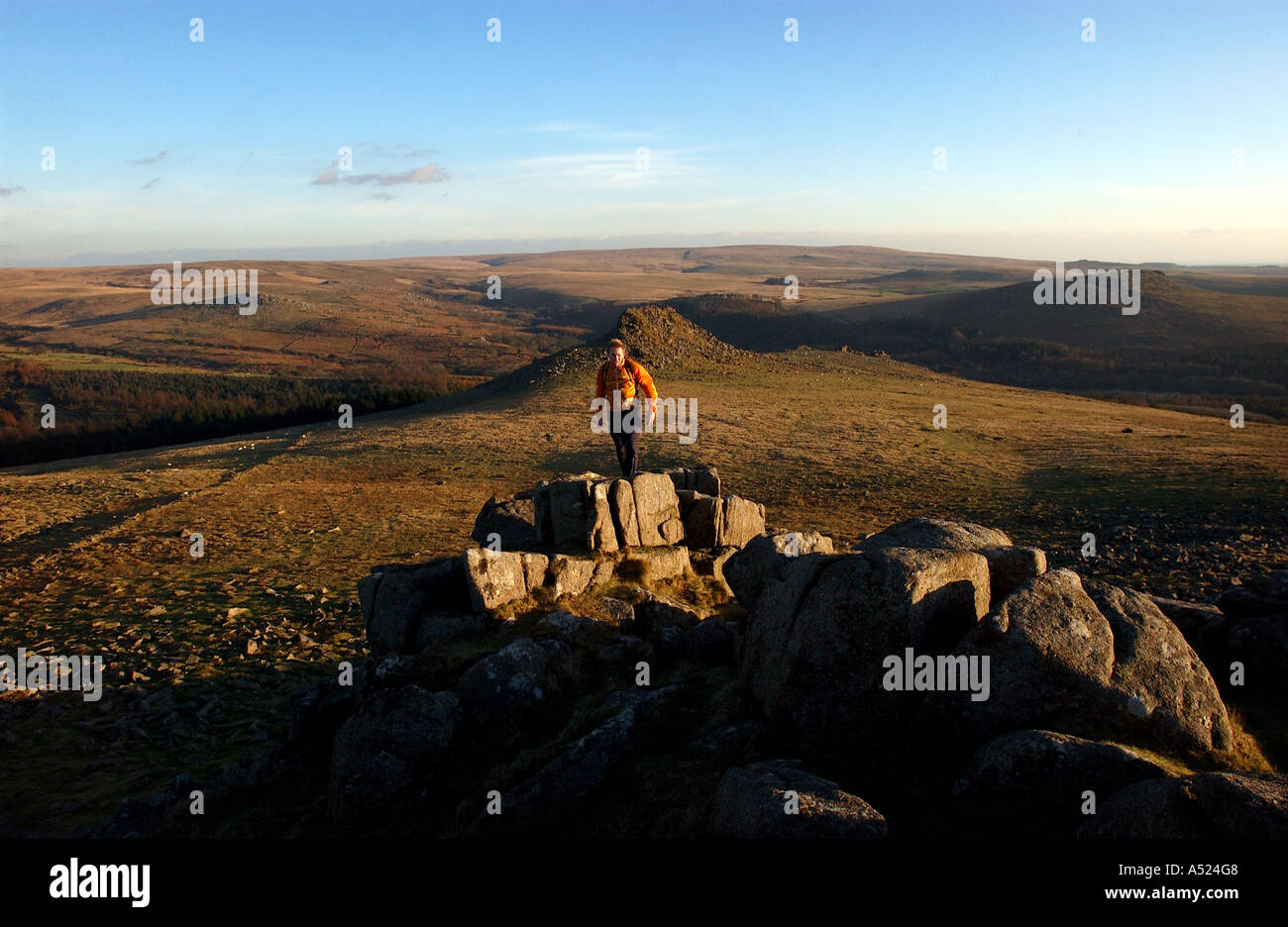 man blurred walking running jumping on tor granite rocks trail autumn ...