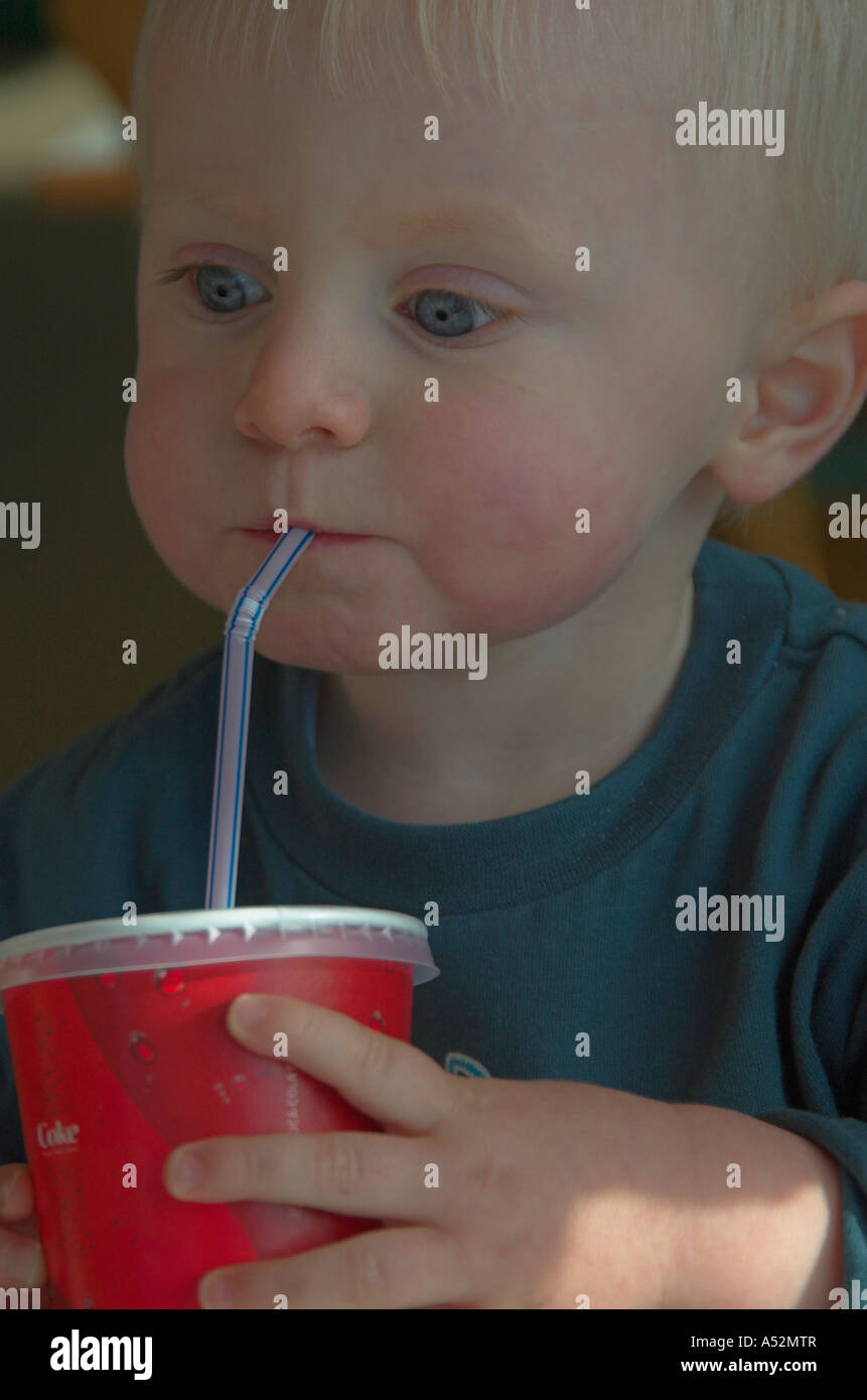 Boy drinking from plastic cup with straw Stock Photo Alamy