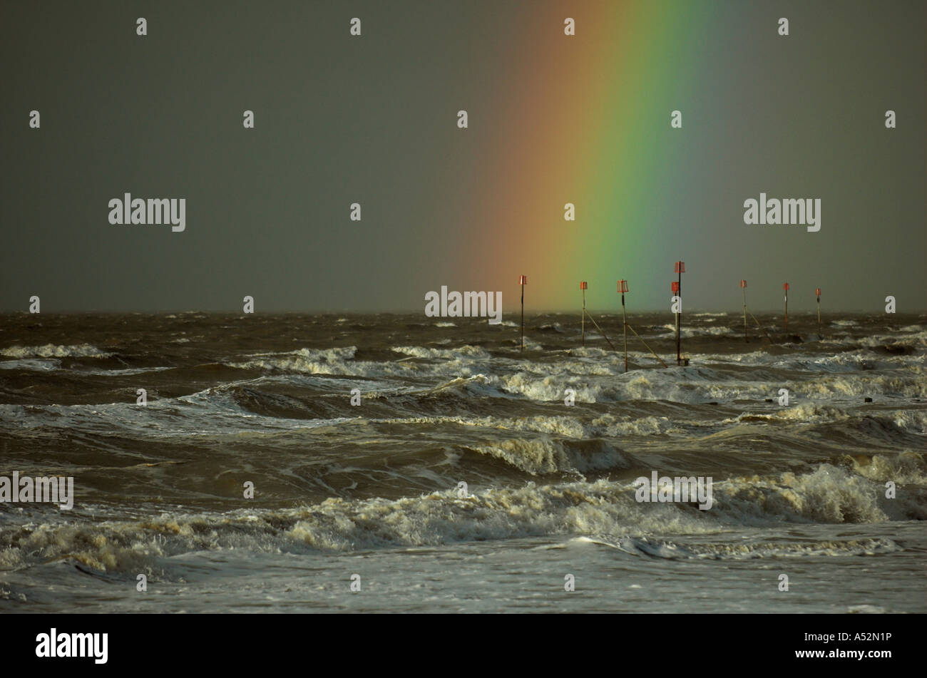Rainbow over stormy sea and groynes Stock Photo - Alamy