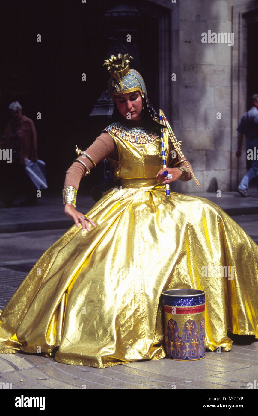 Barcelona, Spain - May 26 2004: Queen Cleopatra sat in a shining golden dress, human statue busker on 26 May 2004 at Las Ramblas Stock Photo