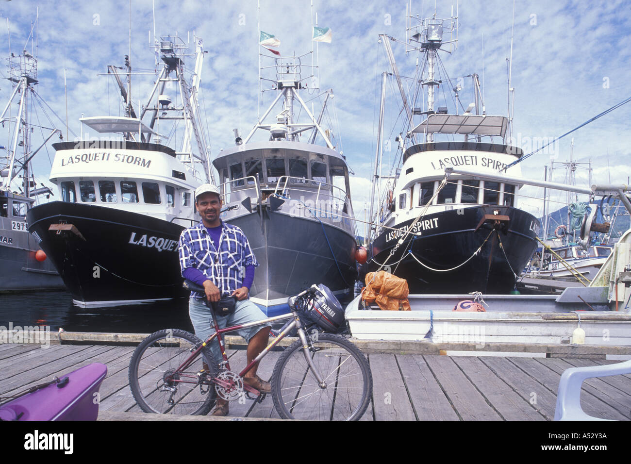 Canada British Columbia Prince Rupert Bicyclist on dock at harbor on summer afternoon Stock Photo