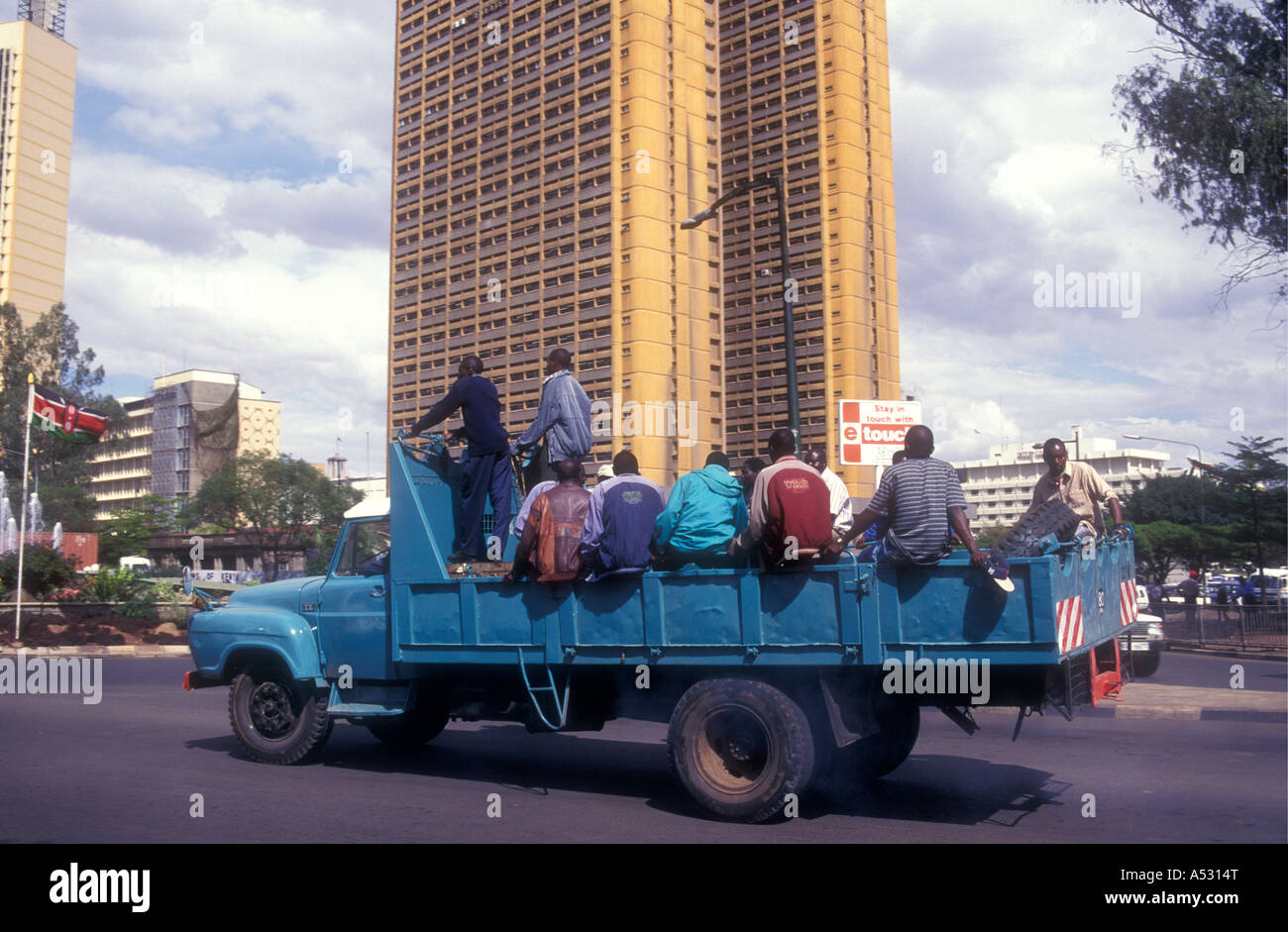 Workmen riding on the back of a lorry on their way to work Nairobi Kenya East Africa Stock Photo