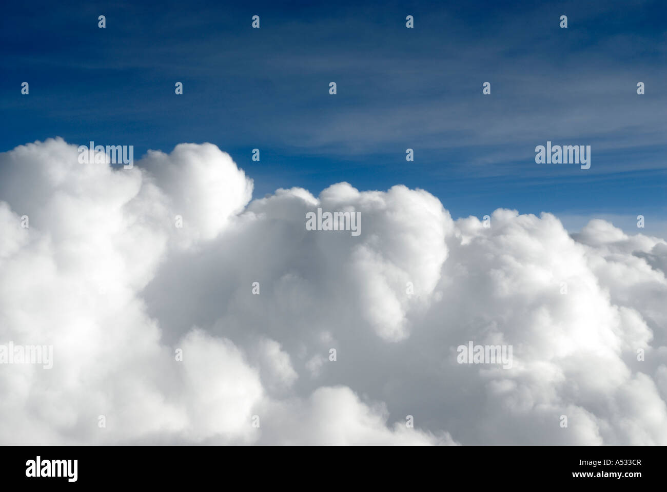 Puffy white cumulus clouds close up from airplane with blue sky Stock Photo