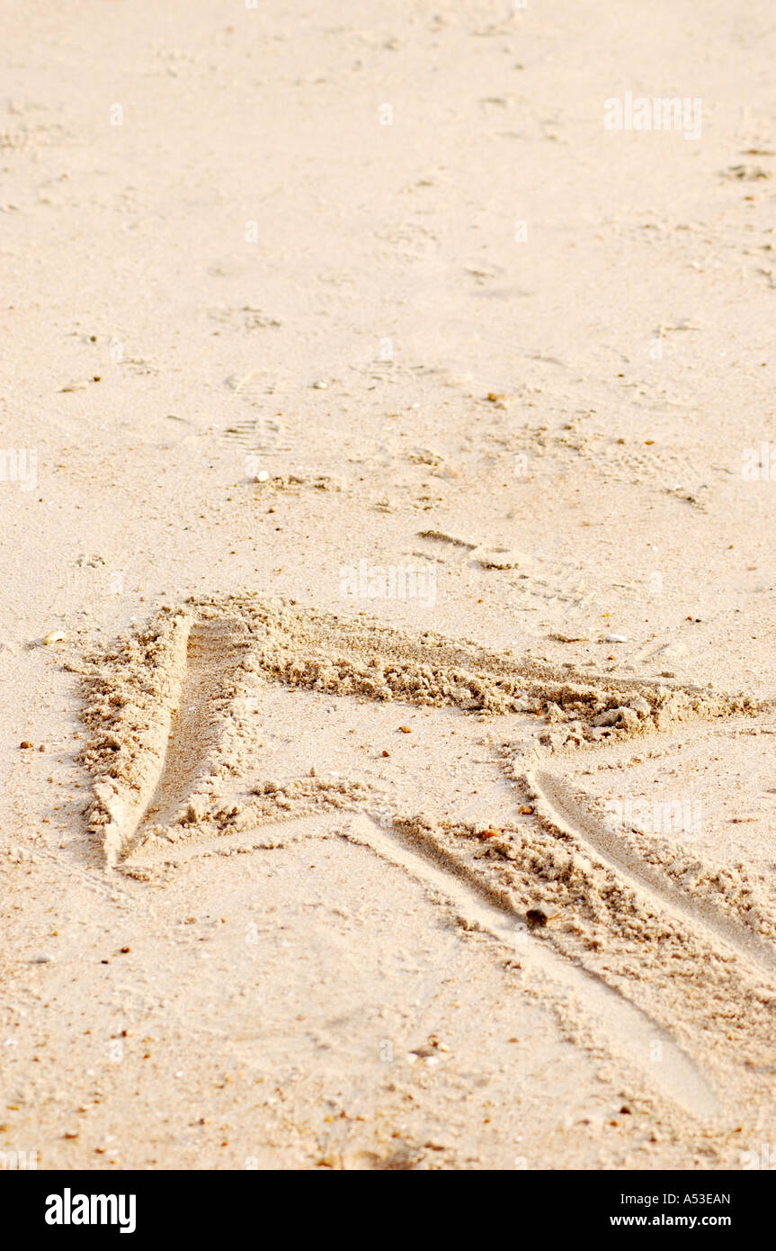 Direction arrow in sand on British beach made by walker in sunshine on the coast of the UK Stock Photo