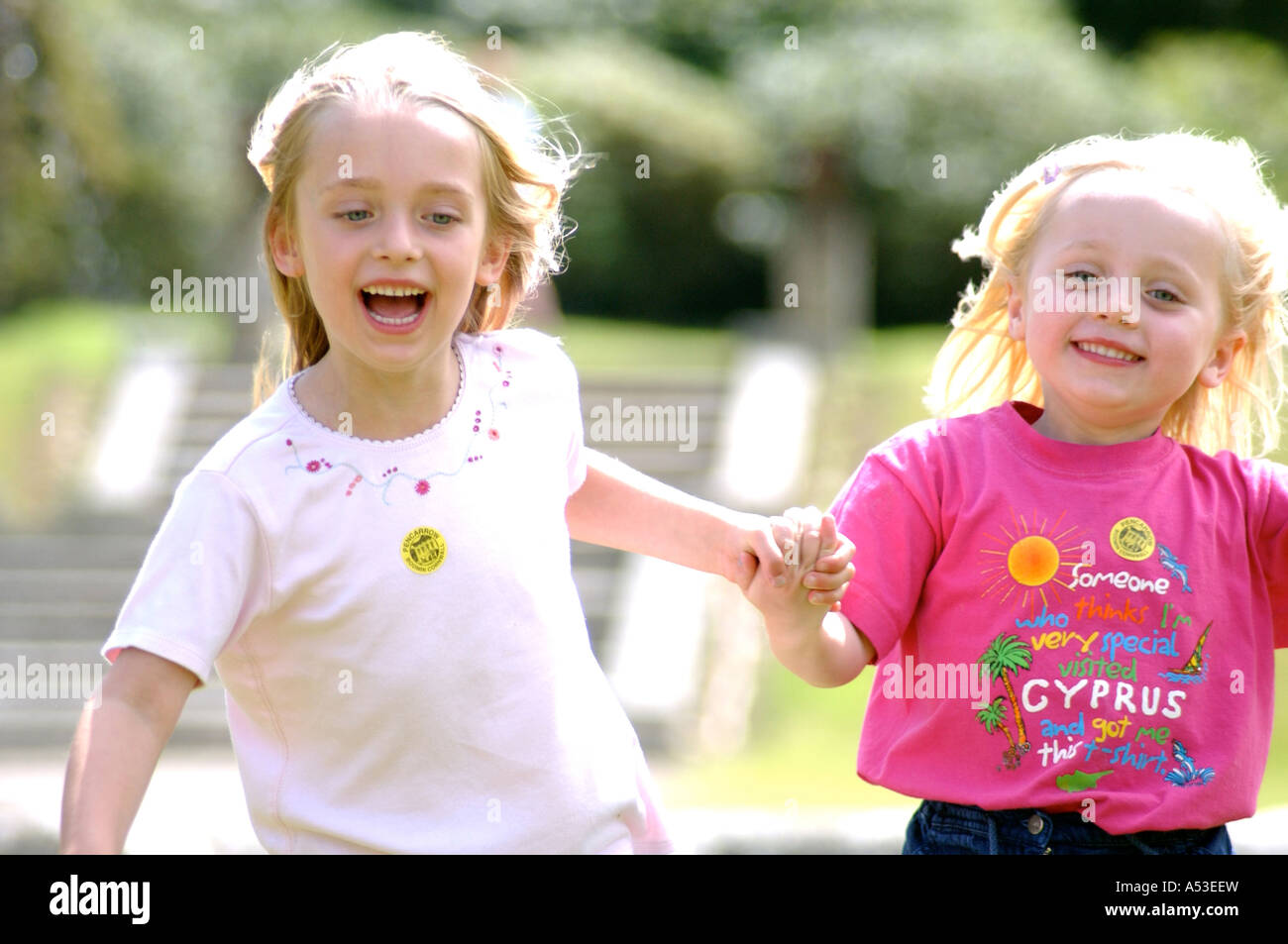 British young friends playing in park London UK running in the sunshine and keeping fit and healthy whilst having fun playing. Stock Photo