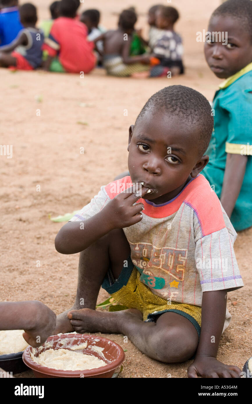 Hungry children eating phala as part of the Joseph Project feeding programme in the village of Buli, Malawi, Africa Stock Photo