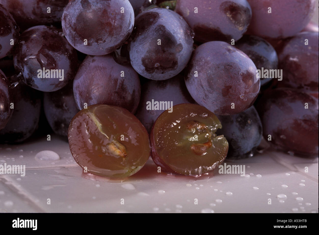 Blue grapes with red inside in studio Stock Photo - Alamy