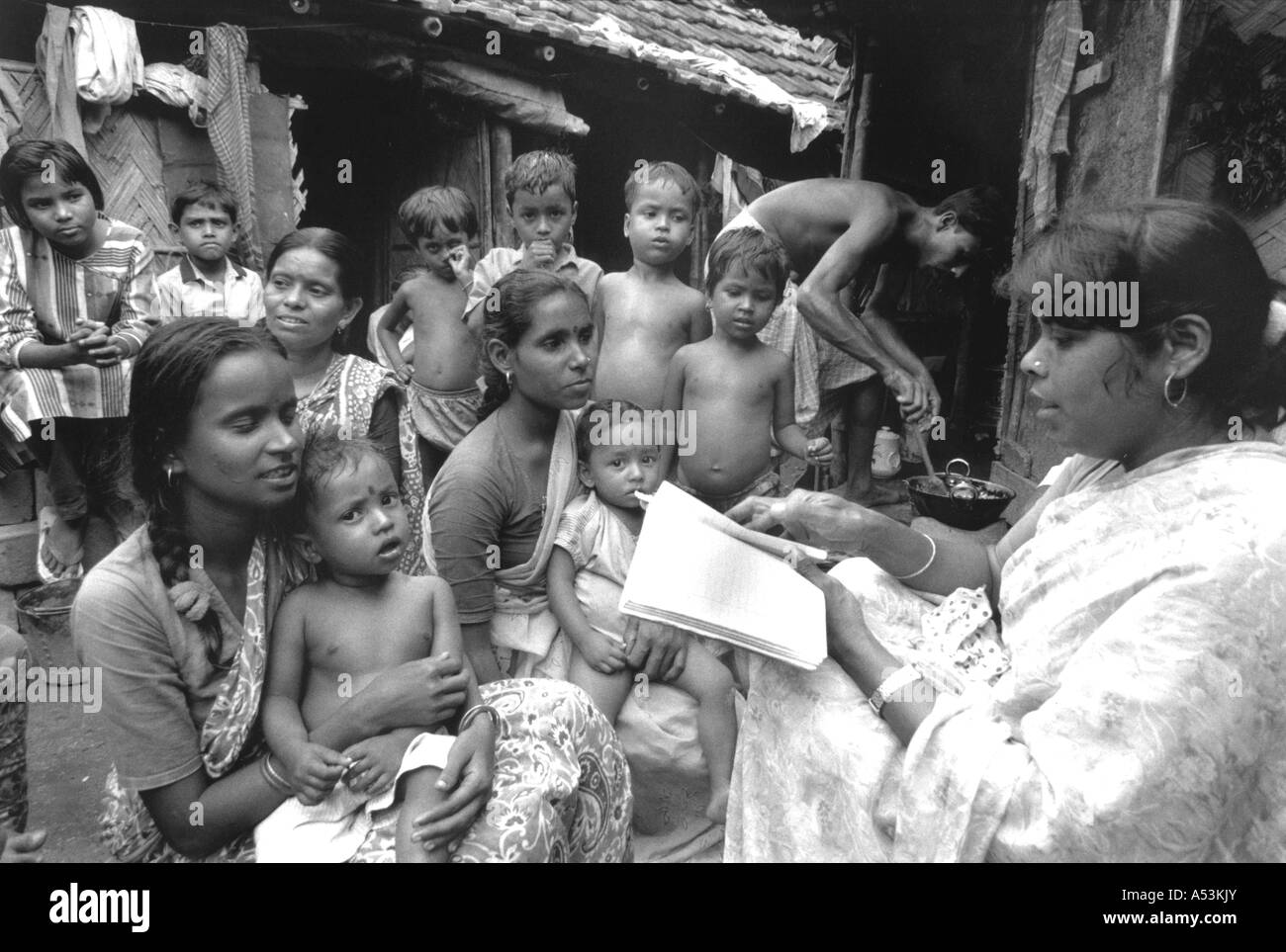 Painet ha1289 077 black and white health awareness community worker visiting family slum calcutta india country developing Stock Photo