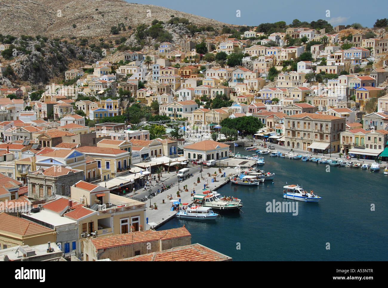 Neo-Classical houses on the hillside above Yialos harbour in Symi Town ...