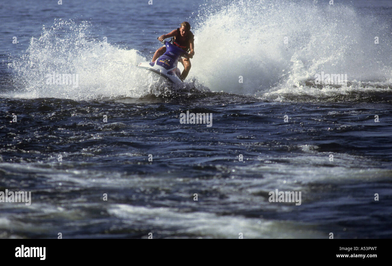 Young Man Riding A Jet Ski,On The Waters Of The Manmade, Lake Powell In Utah ,USA Stock Photo