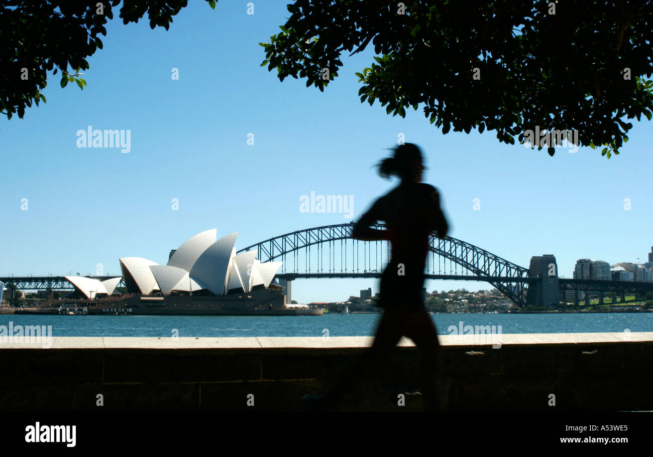 Jogger running by the sydney opera house and harbor harbour bridge in australia Stock Photo Alamy