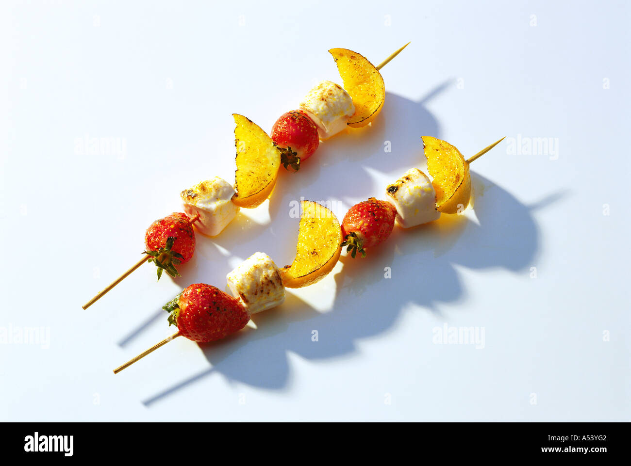 Two sweet strawberry and orange kebabs with marshmallows Stock Photo