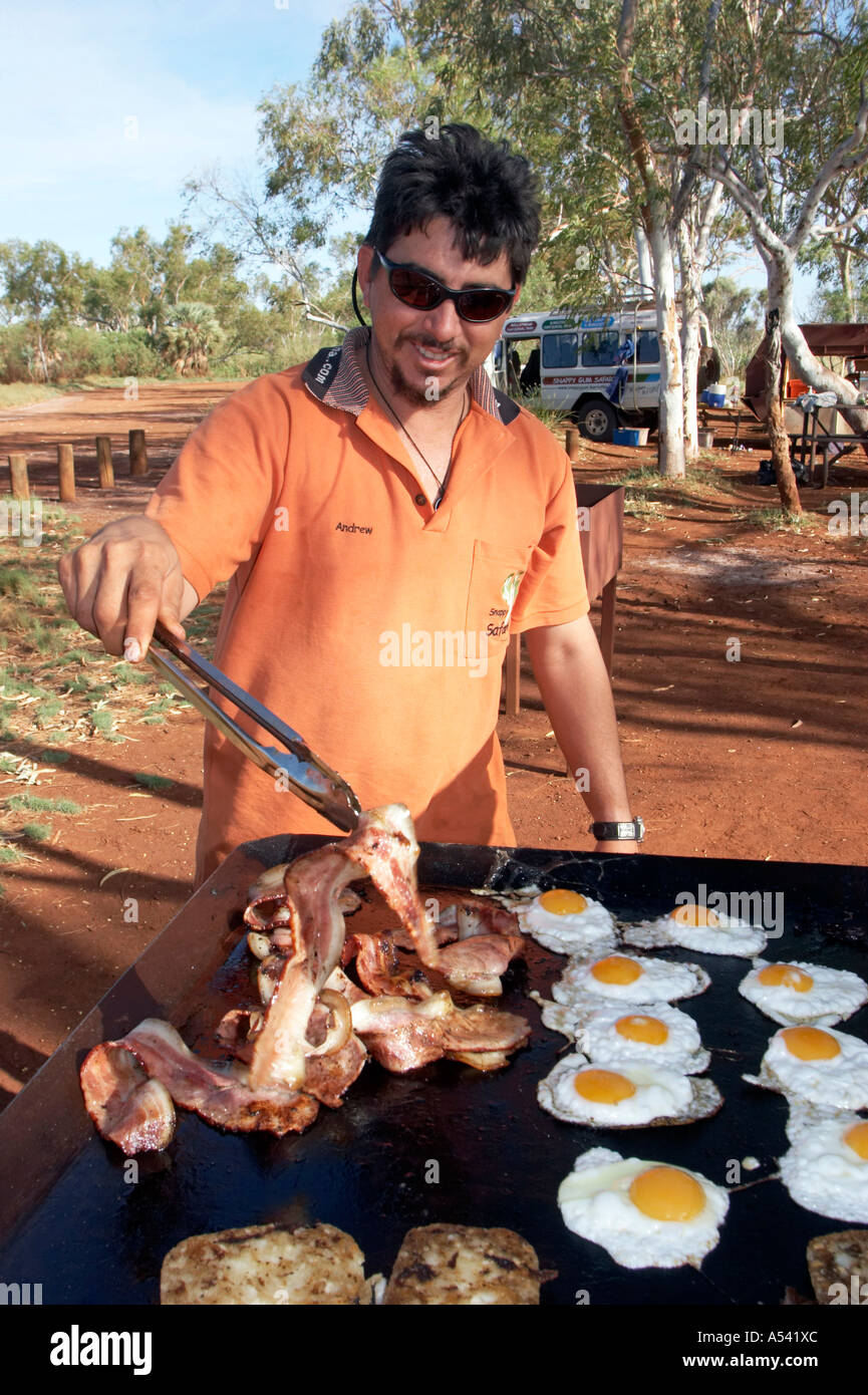 Tour guide Andrew frying breakfast bacon ang fried egg Stock Photo